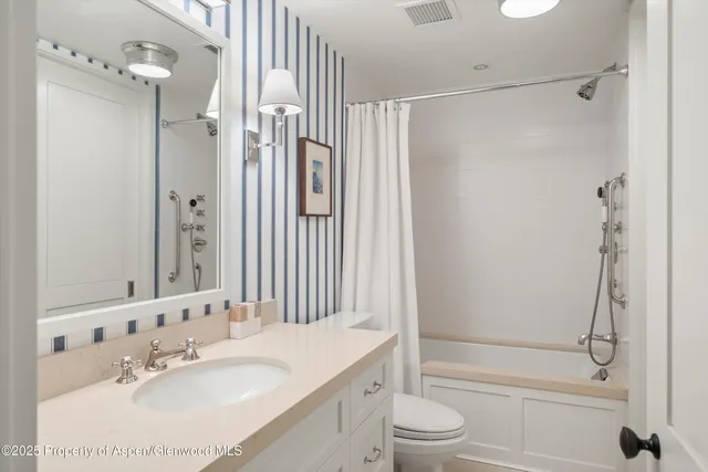 a bathroom with a granite countertop sink toilet and shower
