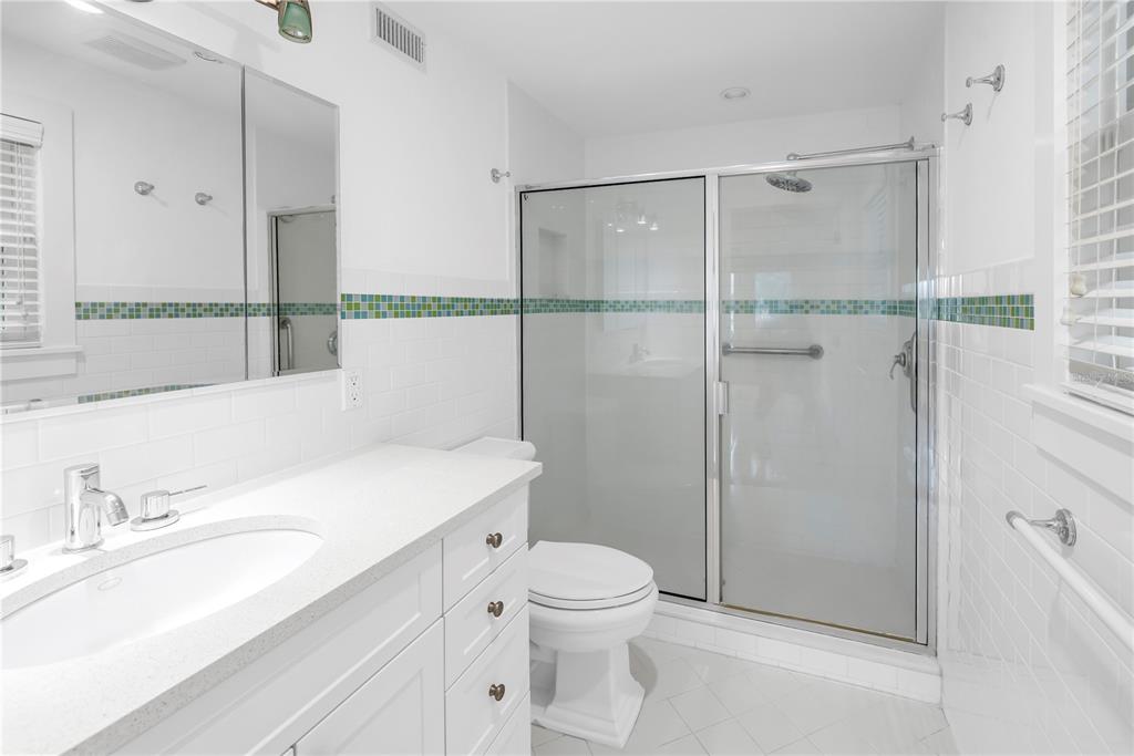 2605 Pass A Grille Way St. Pete Beach, FL 33706 - Photo 14 of 41 a bathroom with a sink toilet vanity and shower