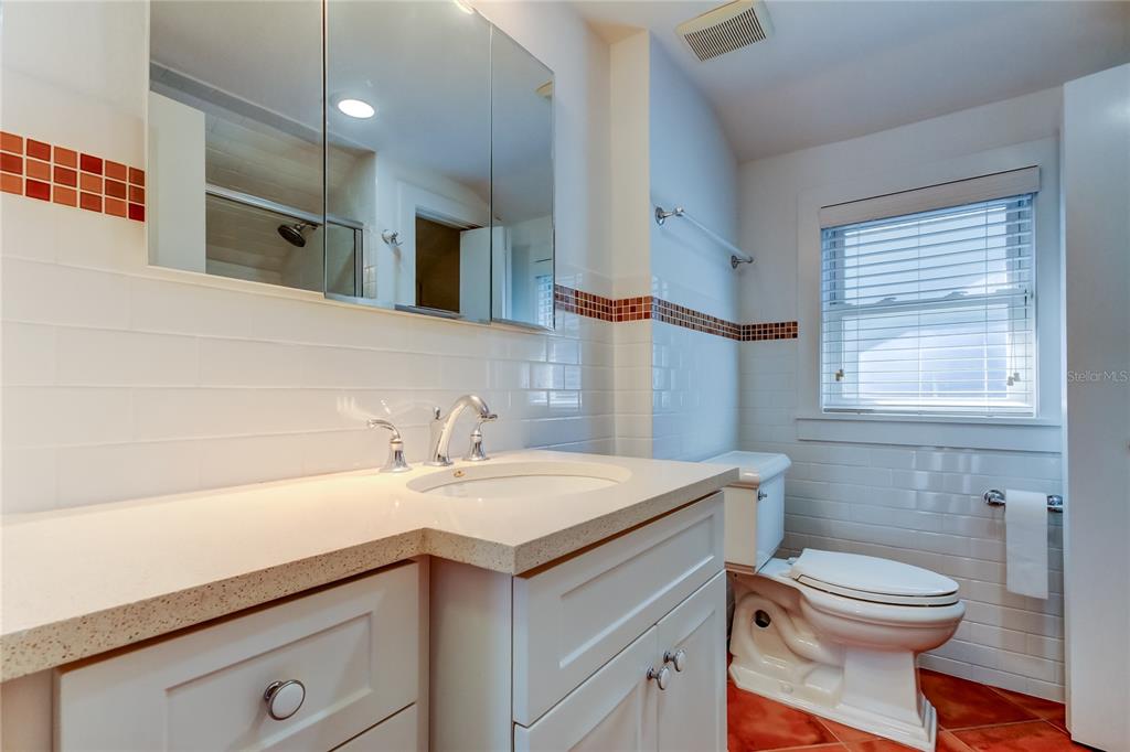 2605 Pass A Grille Way St. Pete Beach, FL 33706 - Photo 27 of 41 a bathroom with a sink a toilet and a mirror