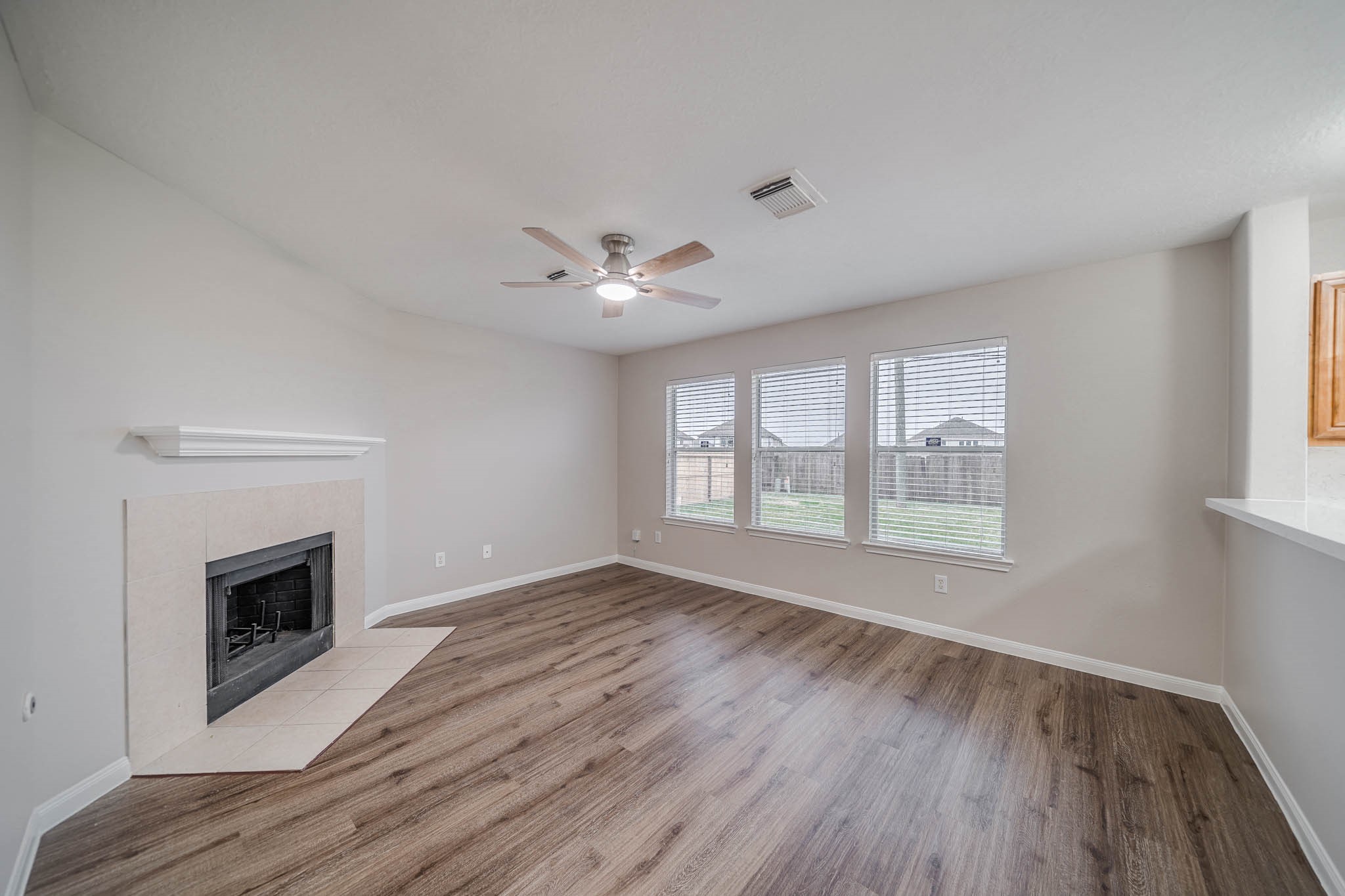 121 Rodeo Drive Manvel, TX 77578 - Photo 6 of 22 a view of an empty room with a fireplace and wooden floor