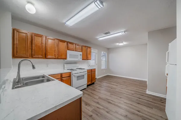 a kitchen with stainless steel appliances granite countertop wooden cabinets a sink and dishwasher