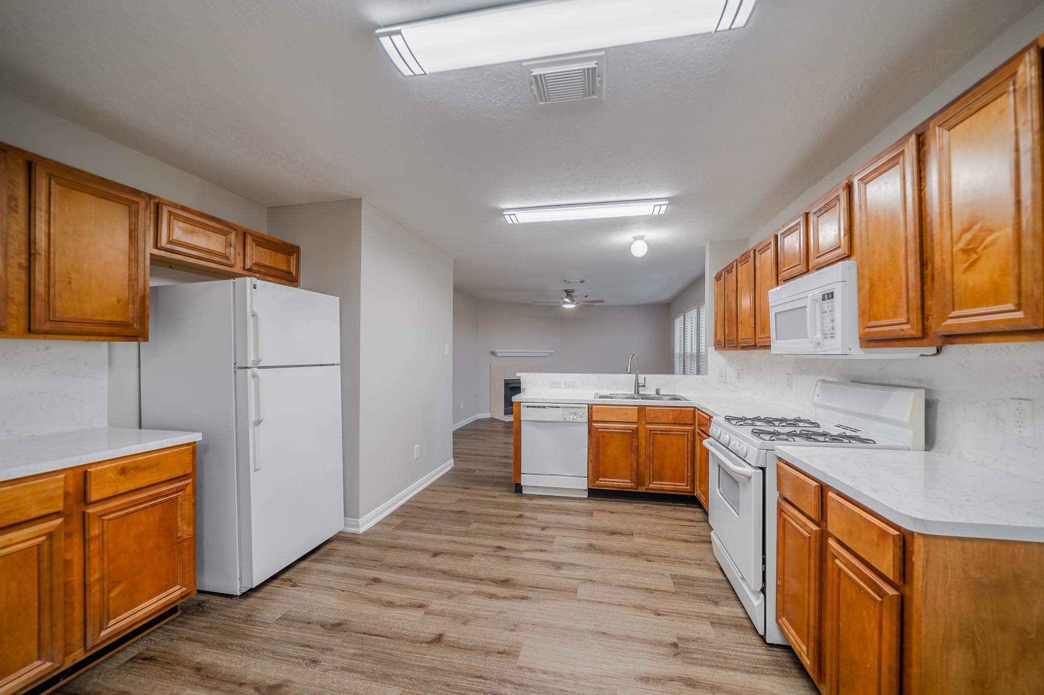 121 Rodeo Drive Manvel, TX 77578 - Photo 9 of 22 a kitchen with stainless steel appliances granite countertop a refrigerator a stove top oven a sink dishwasher and wooden cabinets