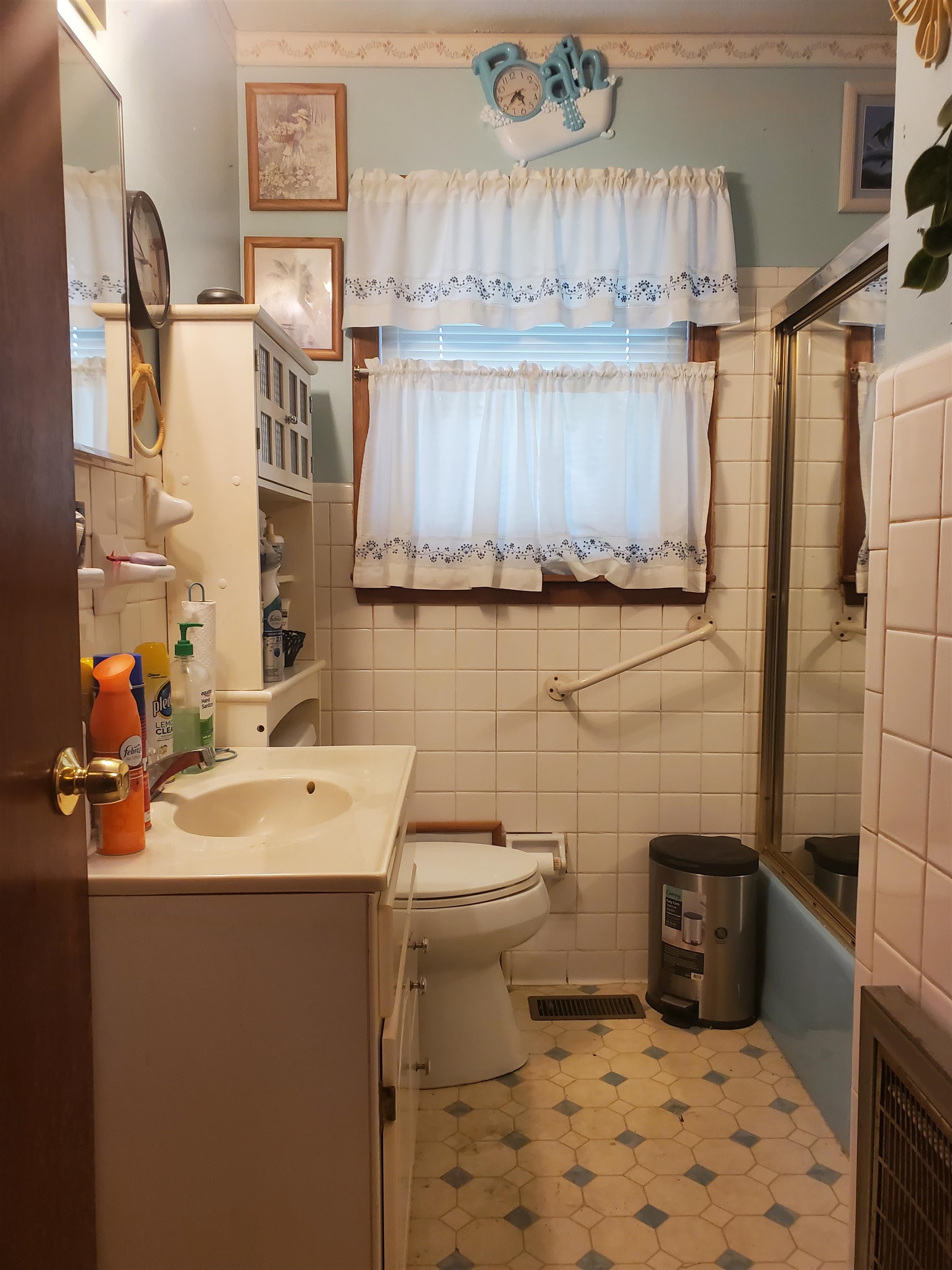 147 Rogers Street Sharon, TN 38255 - Photo 13 of 16 Bathroom featuring a single vanity, white tiled walls, and patterned flooring