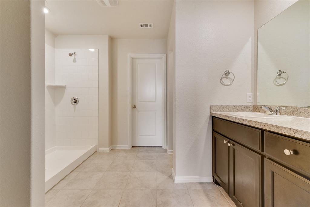 711 Durango Lane Cleburne, TX 76033 - Photo 15 of 26 a bathroom with a granite countertop sink two mirror and shower