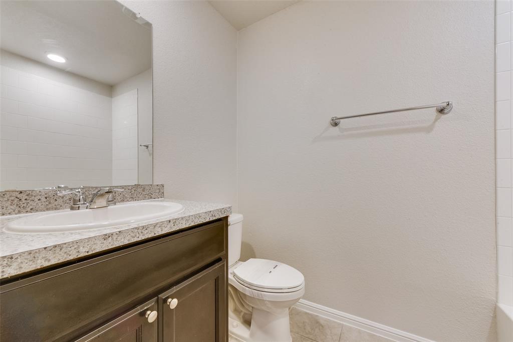 711 Durango Lane Cleburne, TX 76033 - Photo 19 of 26 a bathroom with a granite countertop sink and a toilet