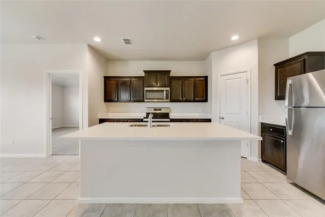 a kitchen with stainless steel appliances a stove sink microwave and cabinets