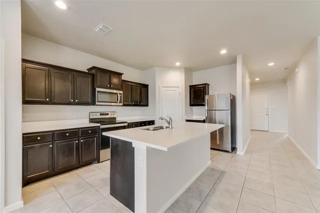 a kitchen with granite countertop a sink and stainless steel appliances