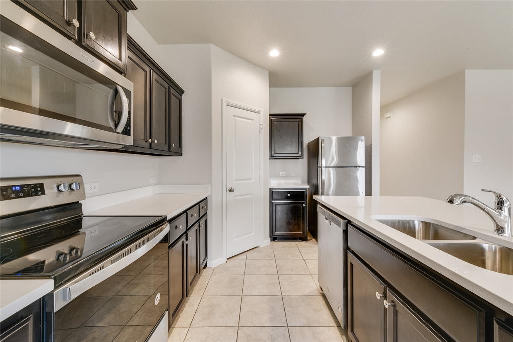 711 Durango Lane Cleburne, TX 76033 - Photo 10 of 26 a kitchen with granite countertop a sink and stainless steel appliances