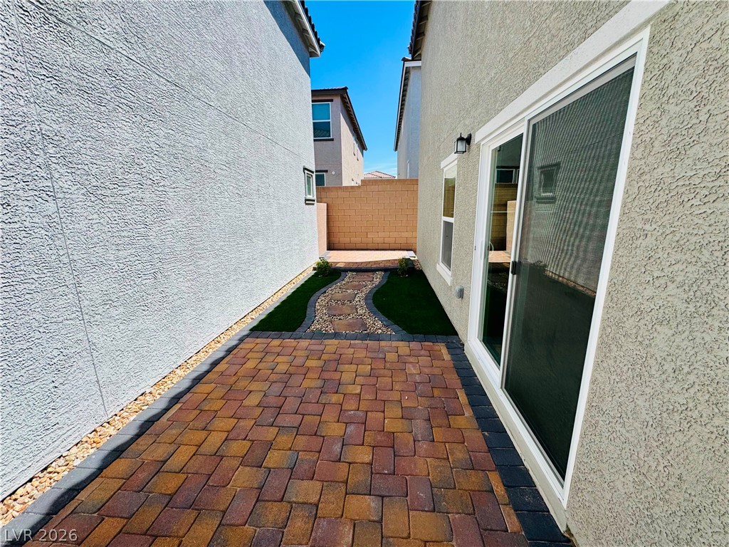 9249 Innot Avenue Las Vegas, NV 89148 - Photo 22 of 24 A neatly paved pathway and landscaped strip create a welcoming transition between structures.