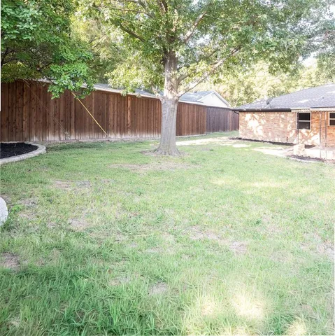 a view of house with backyard and a slide
