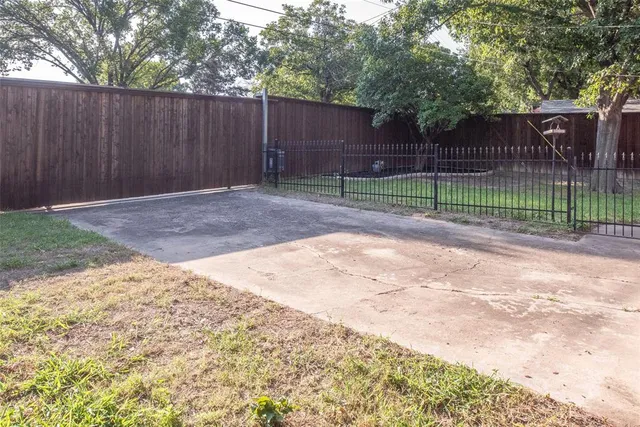 a view of a backyard with wooden fence
