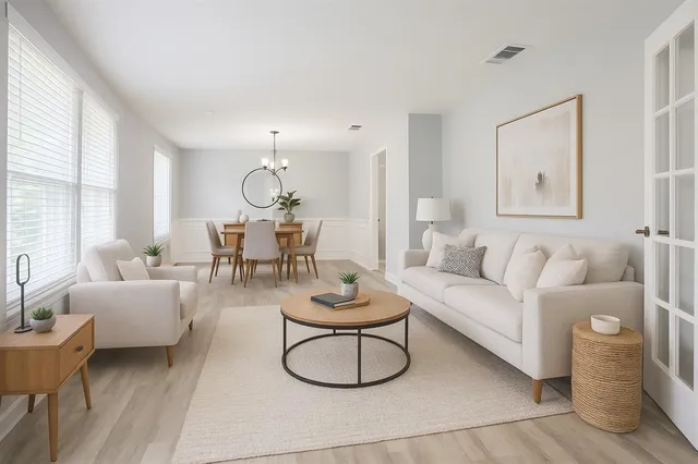 a living room with furniture potted plant and a large window