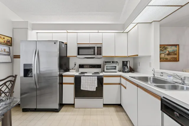 a kitchen with stainless steel appliances granite countertop a refrigerator a sink a stove a microwave and island