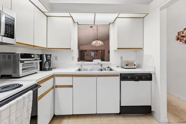 a kitchen with white cabinets and white appliances