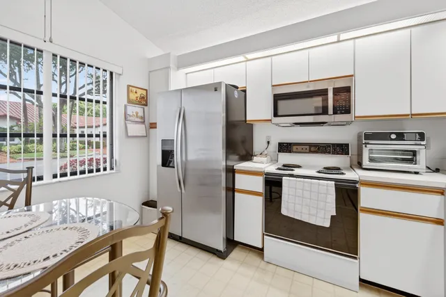 a kitchen with stainless steel appliances granite countertop a stove a refrigerator and a microwave