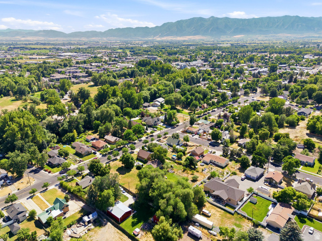 300 East S, Unit 2 Logan, UT 84321 - Photo 6 of 38 Aerial perspective showcasing a residential neighborhood with mature trees and mountain backdrop