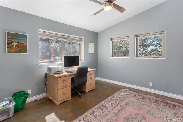 a view of a workspace with furniture and a window