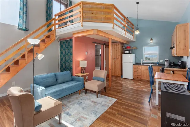 a living room with furniture a fireplace and a kitchen view