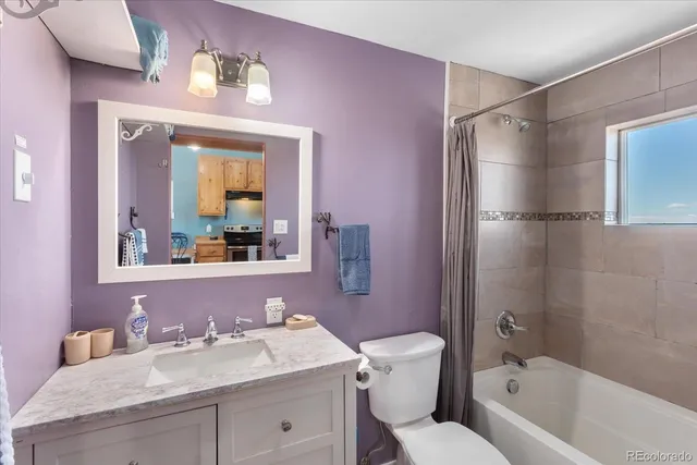 a bathroom with a granite countertop sink toilet tub and shower