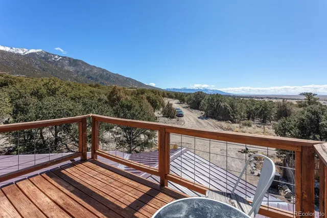 a view of balcony with wooden floor and mountains