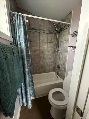 a bathroom with a shower a toilet and bathtub