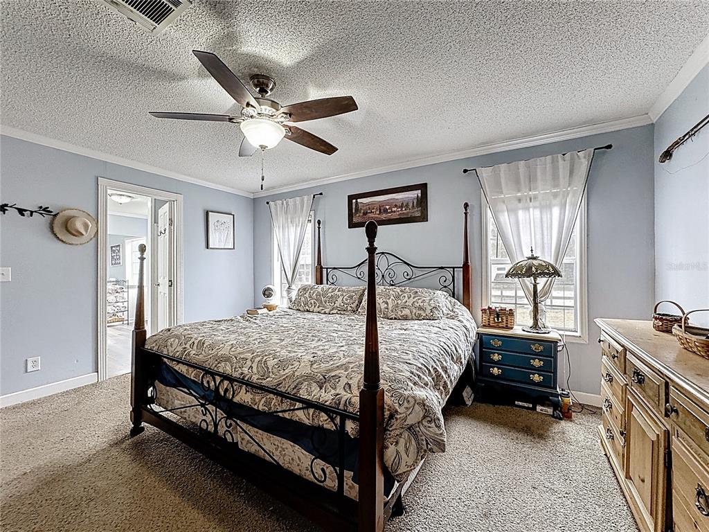 3230 Empire Church Road Groveland, FL 34736 - Photo 12 of 29 a bedroom with a bed and a chandelier