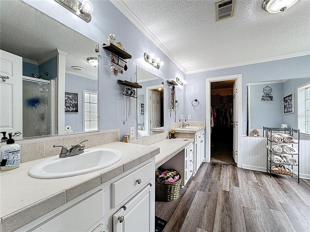 3230 Empire Church Road Groveland, FL 34736 - Photo 13 of 29 a spacious bathroom with a granite countertop sink window and a mirror