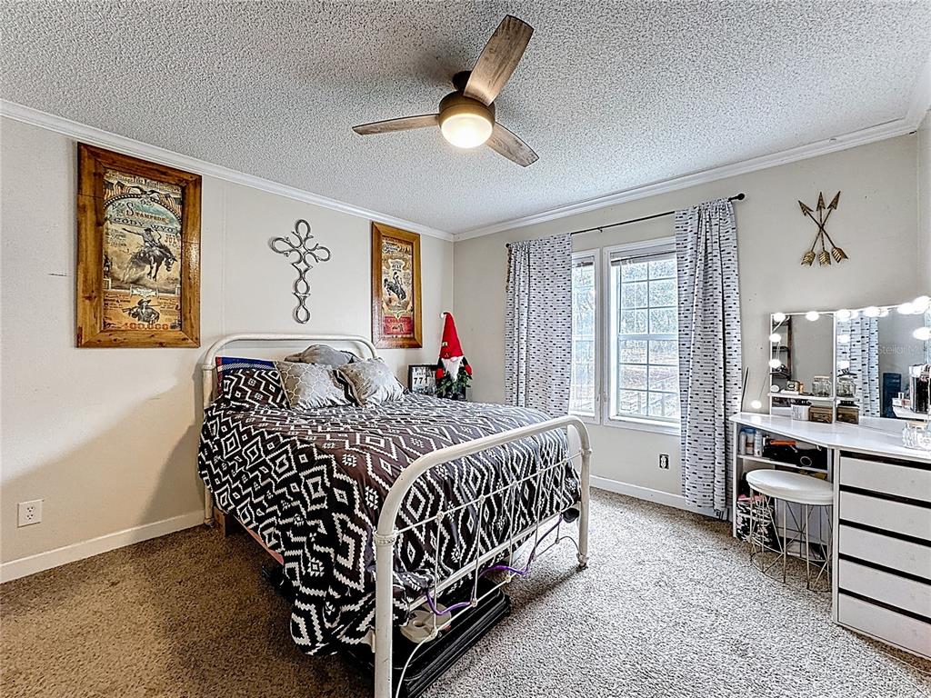 3230 Empire Church Road Groveland, FL 34736 - Photo 14 of 29 a bedroom with a bed and a chandelier