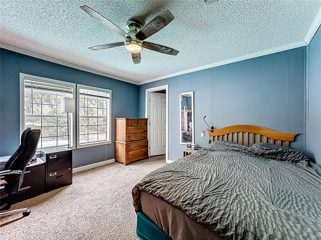 3230 Empire Church Road Groveland, FL 34736 - Photo 15 of 29 a bedroom with a bed and a large window