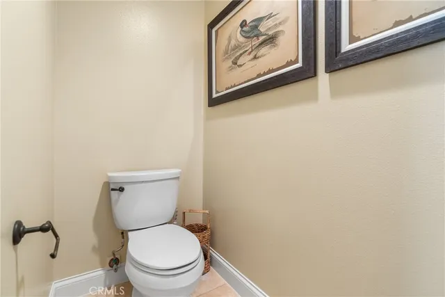 a white toilet sitting next to a white wall