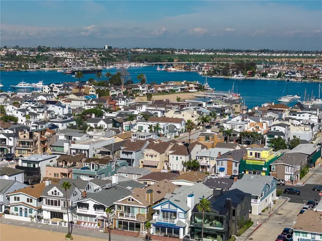 an aerial view of a city with lots of residential buildings and ocean view in back
