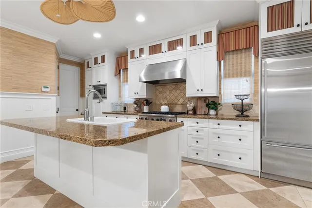 a kitchen with stainless steel appliances granite countertop a sink and dishwasher with white cabinets