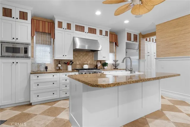 a kitchen with cabinets appliances a sink and a counter top space