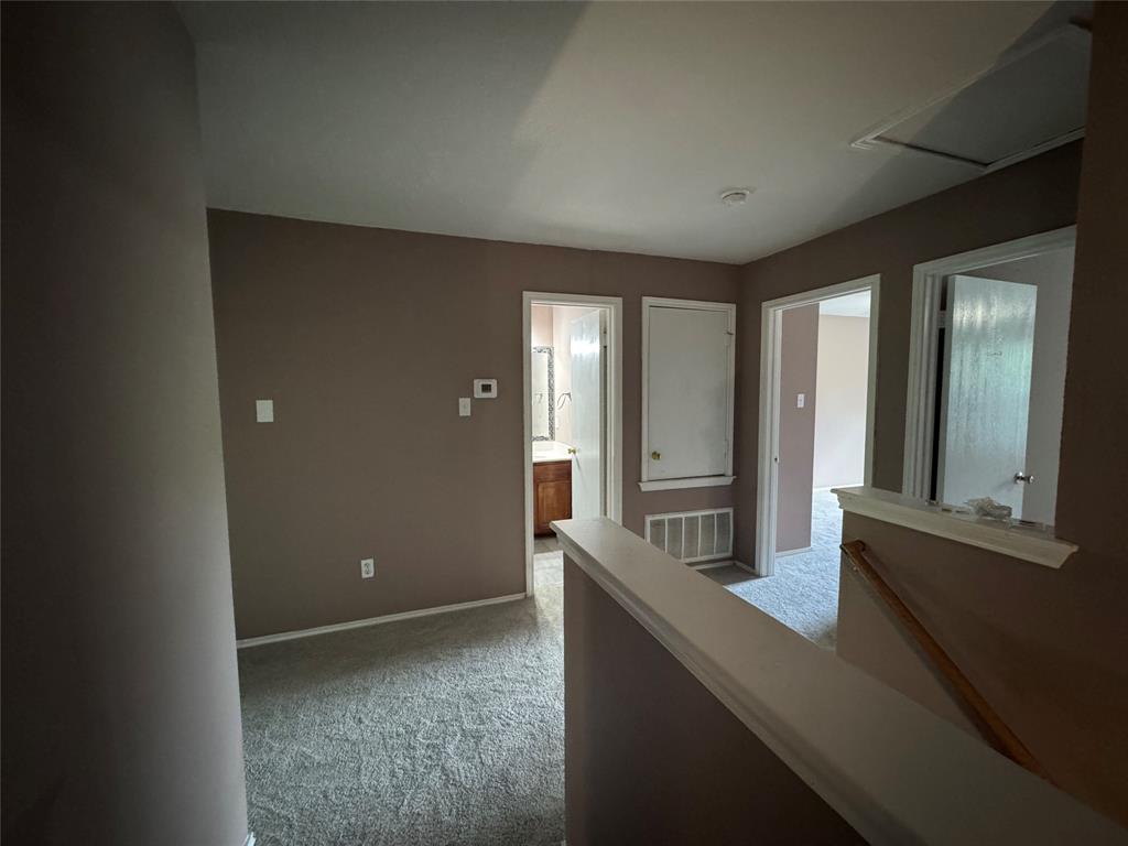 3200 Crownover Street Austin, TX 78725 - Photo 15 of 23 A plush carpeted hallway leads to multiple rooms, offering versatility for any lifestyle.