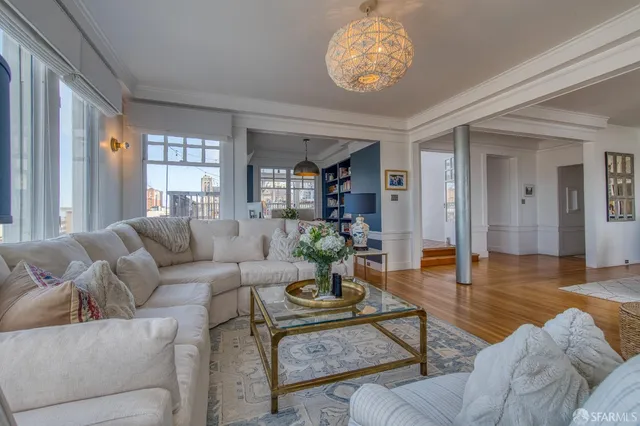 a living room with furniture a wooden floor and a large window
