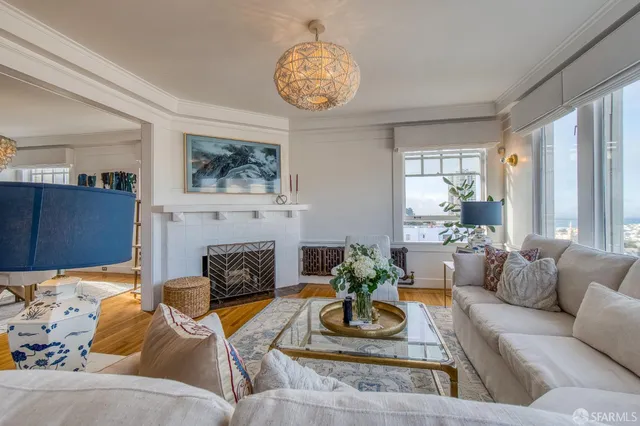 a living room with furniture a fireplace and a large window