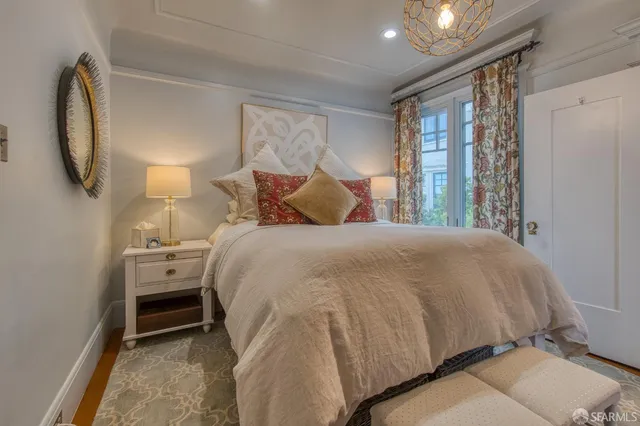 a bed sitting in a bedroom next to a window