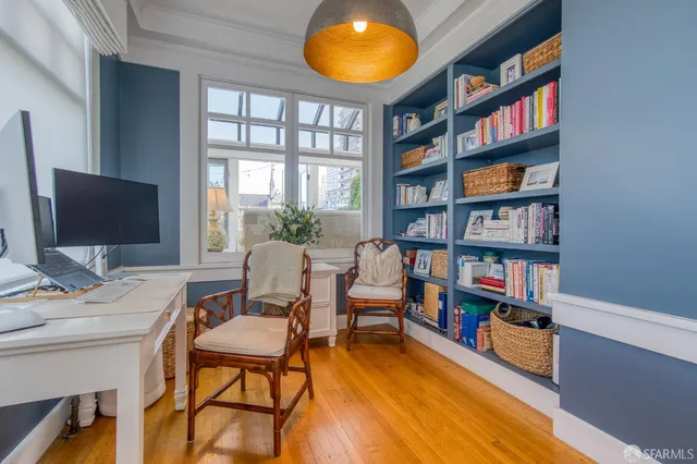 a view of a workspace with furniture and a bookshelf