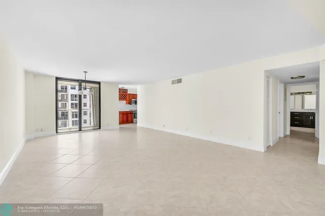 an empty room with bookshelf and natural light
