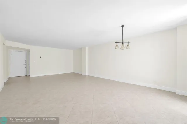 an empty room with chandelier fan