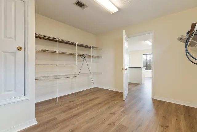 a view of a room with wooden floor and white walls