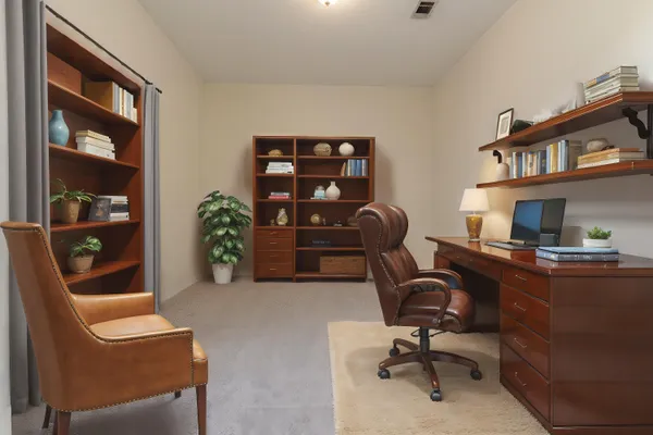 a view of a workspace with furniture and a window