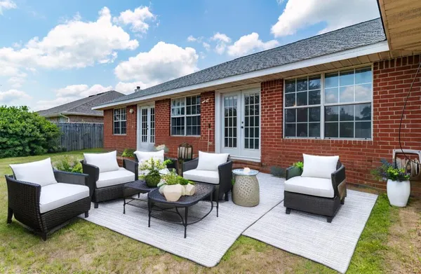 a view of a patio with couches table and chairs and potted plants