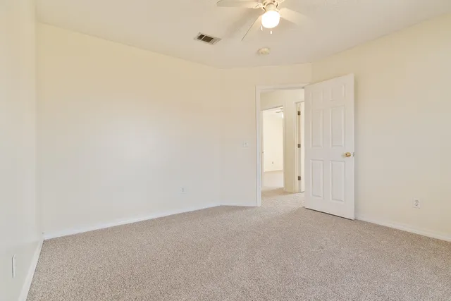 an empty room with a ceiling fan and a window