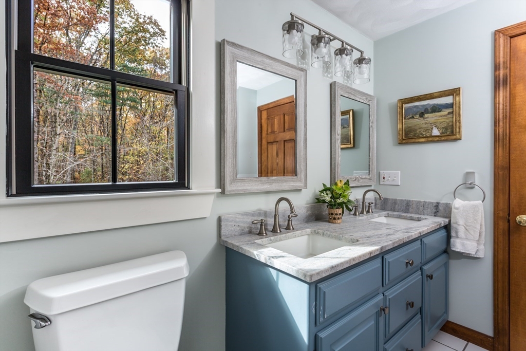 8 Bubbling Brook Road Franklin, MA 02038 - Photo 25 of 46 a bathroom with a granite countertop sink mirror and toilet