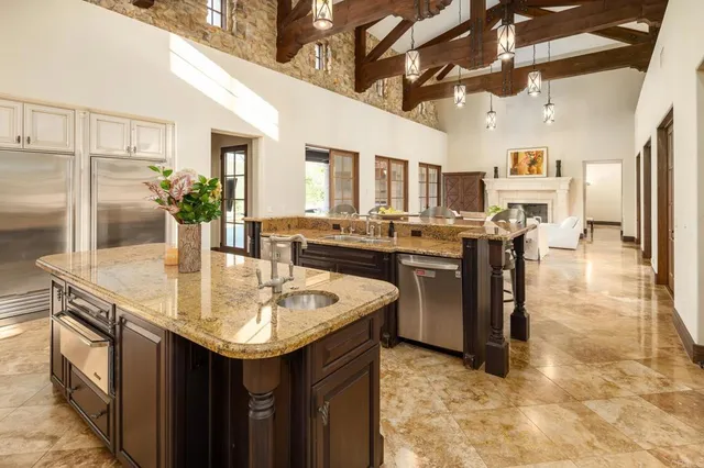 a kitchen with stainless steel appliances granite countertop a sink and a refrigerator