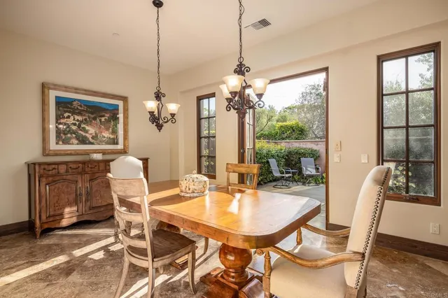 a dining room with furniture a chandelier and wooden floor