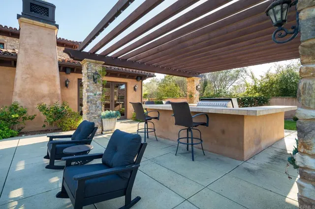 a view of a patio with table and chairs potted plants with wooden floor and fence