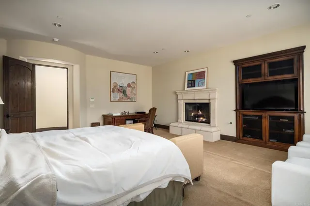 a spacious bedroom with a bed and a flat screen tv