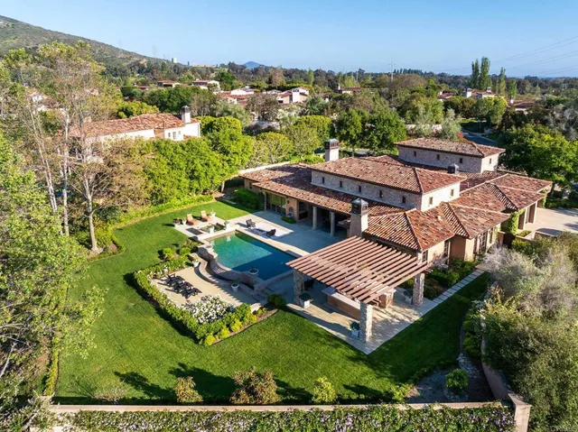 an aerial view of a house with a yard basket ball court and outdoor seating